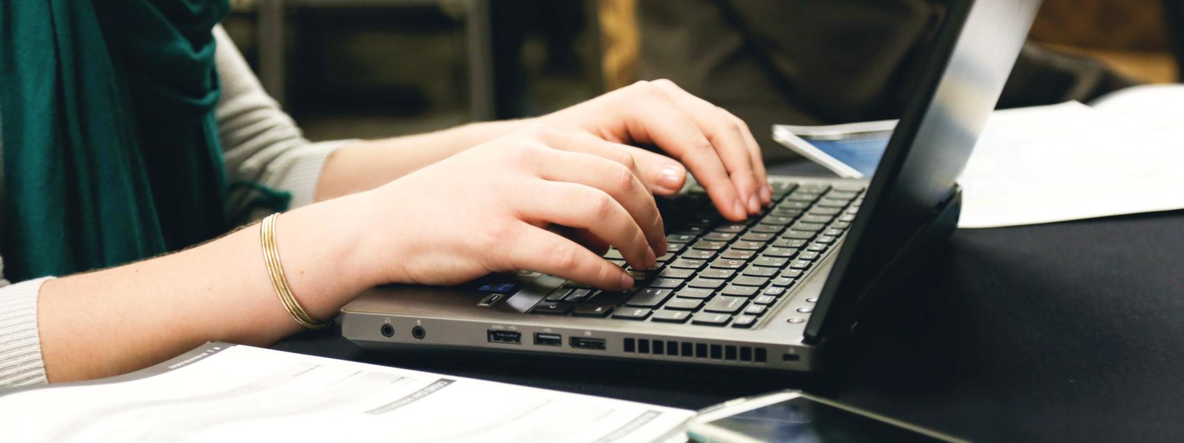 close up shot of someone typing on a laptop