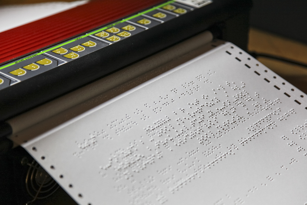 A braille embosser printing pages for a book