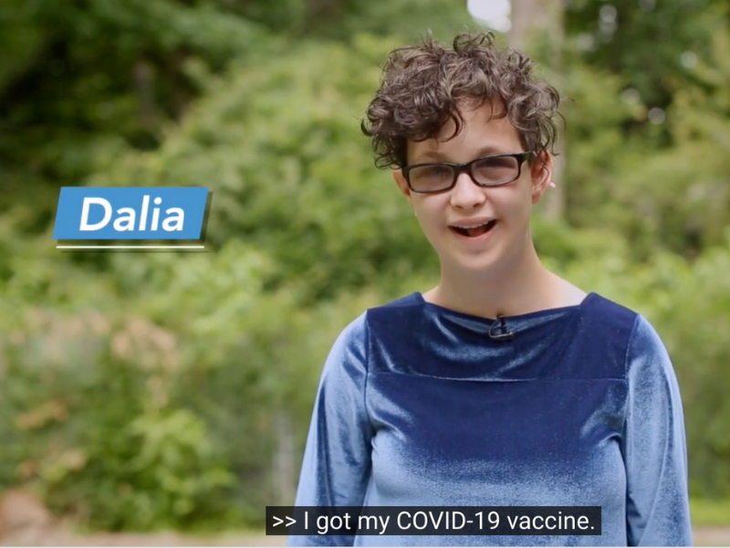 A young woman named Dalia in a blue shirt saying she has gotten her vaccine.