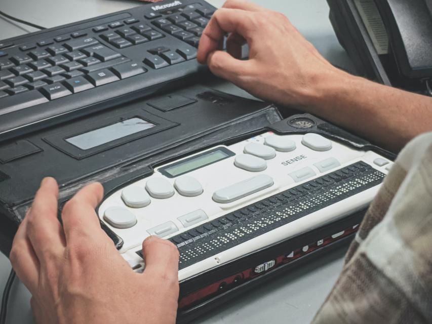 a man at work using a braille keyboard.